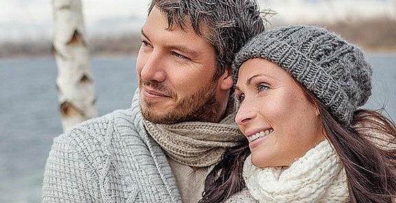 Paar steht zusammen vor einem See.