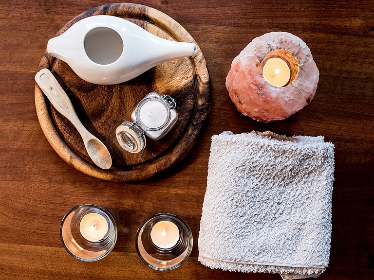 Utensilien für eine Nasenspülung auf einem braunen Holztisch.