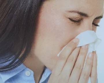 Frau putzt sich die Nase