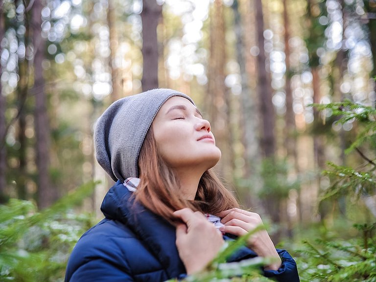 Frau im Wald genießt den Geruch.
