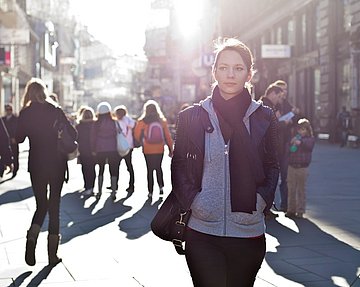 Frau läuft wegen Ansteckungsgefahr misstrauisch durch eine Stadt. 
